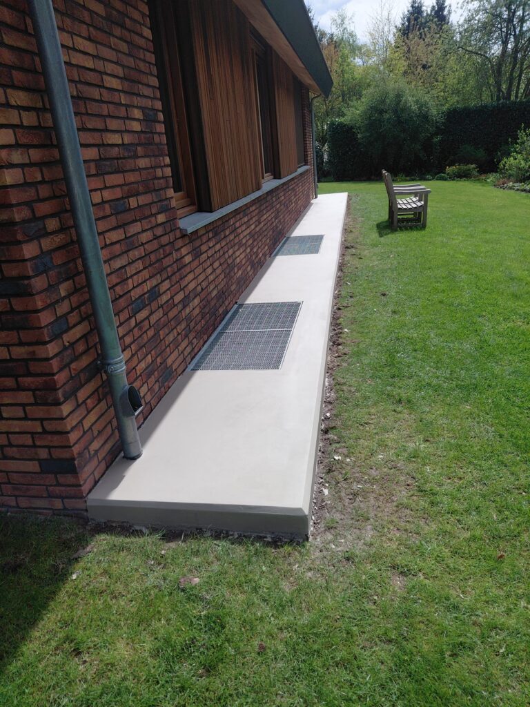 Concrete pathway beside a brick house